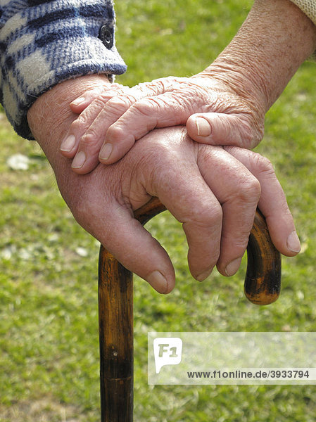 Hände eines Seniorenpaares am Stock
