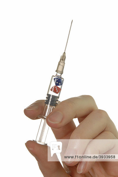 Frauenhand mit Spritze  in der Spritze sind zwei Würfel  Symbolbild für Risiko bei Grippeimpfung