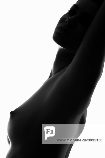 Scherenschnittaufnahme einer nackt dastehenden jungen Frau mit Blick zum Betrachter