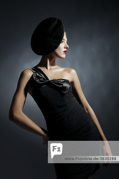 Junge Frau im schwarzen Kleid mit schwarzem Hut  Fashion