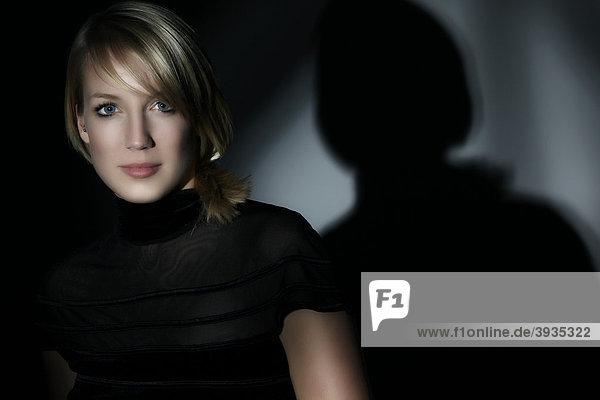 Portrait einer jungen Frau  von Schatten umgeben  direkter Blick