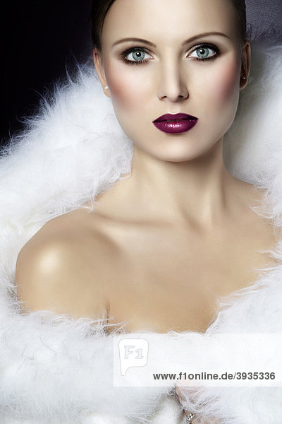 Portrait einer jungen Frau  eingehüllt in ein weißes Fell  auberginefarbener Lippenstift  direkter Blick  Fashion  Glamour mund