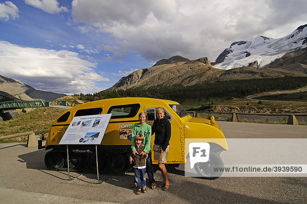 Women and children in front of an old snowmobile  Icefields Parkway  Columbia Icefield  Jasper National Park  Alberta  Canada