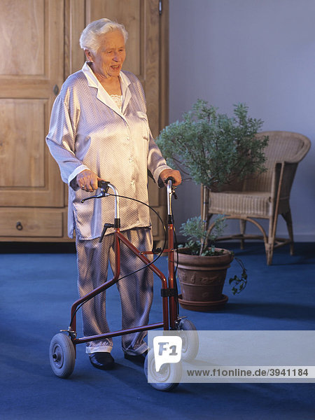 A senior citizen moving about in her apartment with a walker