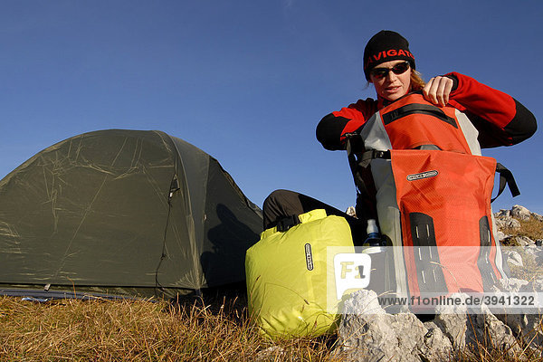 Wanderer  junge Frau baut Biwak mit Zelt  Schlafsack  Rucksack und Isomatte auf  Heidachstellwand  Rofan  Achensee  Tirol  Österreich  Europa