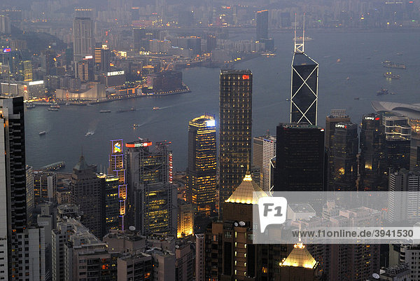 Blick vom Victoria Peak auf das abendlich erleuchtete Hongkong mit Wolkenkratzern und Hochhäusern von Central und Kowloon  Hongkong  China  Asien