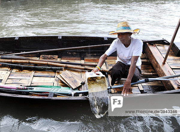 Man pouring water from his boat  Bangkok  Thailand  Asia