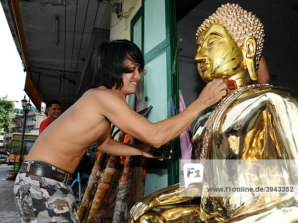 Mann vergoldet einen Buddha  Bangkok  Thailand  Asien
