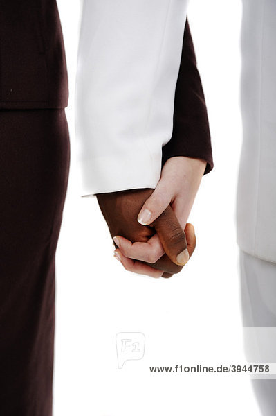 Dunkelhäutiger Mann und weiße Frau halten Hände