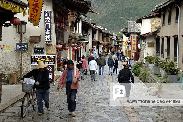 Einheimische und Touristen in einer Altstadtgasse der tibetischen Stadt  Zhongdian  Shangri-La  Provinz Yunnan  Volksrepublik China  Asien