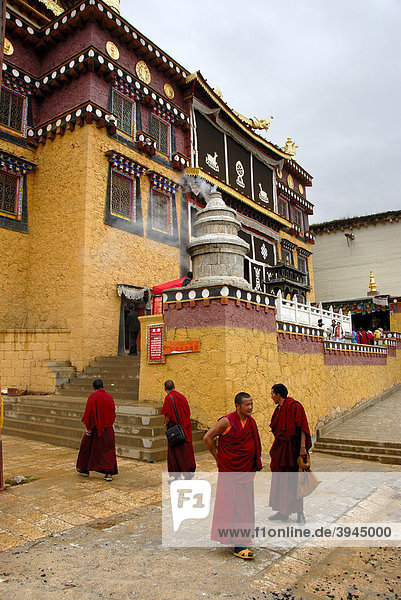 Tibetan Buddhist monks in red robes in front of the temple  Monastery Ganden Sumtseling Gompa  Zhongdian  Shangri-La  Yunnan Province  People's Republic of China  Asia