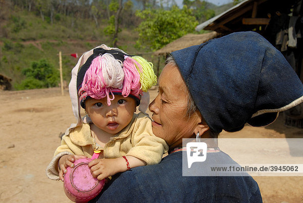 Armut  Portrait  Ethnologie  Frau der Yao Ethnie gekleidet in Tracht mit Baby im Arm  Dorf Ban Houeyyoum  Distrikt Gnot Ou  Yot Ou  Provinz Phongsali  Phongsaly  Laos  Südostasien  Asien
