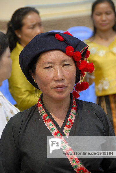 Portrait  Frau der Phunoi Ethnie  traditionelle Kleidung  Kopfbedeckung mit roten Bommeln  Phongsali  Laos  Südostasien  Asien