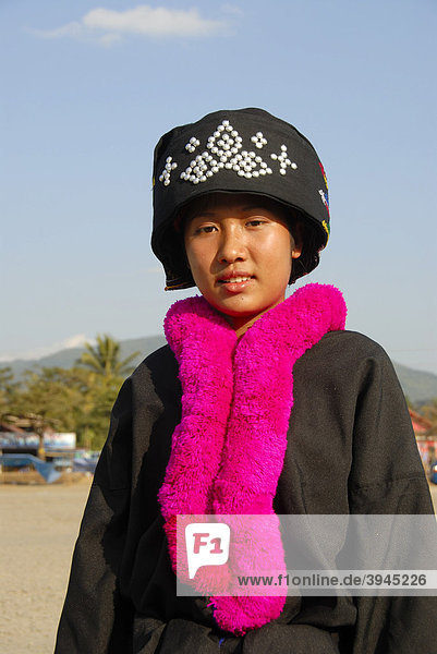 Portrait  junge Frau der Yao Ethnie  Mien  in Tracht  traditionelle Kleidung  Kopfbedeckung  rosa-farbener wolliger Schal  Vang Vieng  Laos  Südostasien  Asien