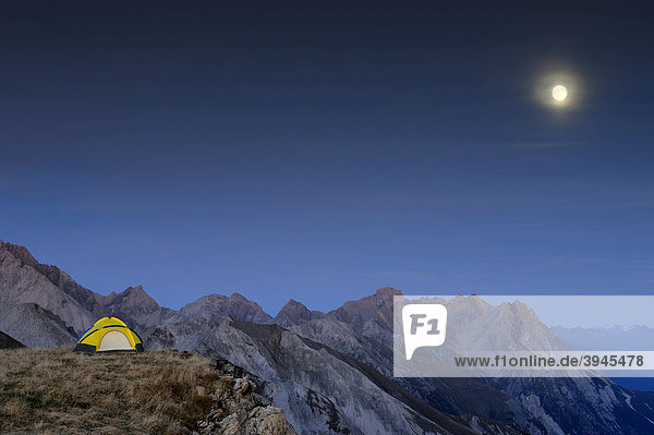 Zelt auf Hochfläche vor Alpengipfeln mit Vollmond Kaisers Lechtal Außerfern Tirol Östereich Europa