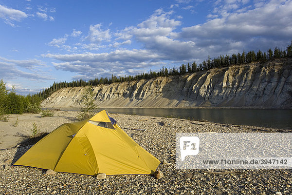 Zelt auf einer Kiesbank  dahinter eine hohe Uferböschung  oberer Liard River  Yukon Territory  Kanada
