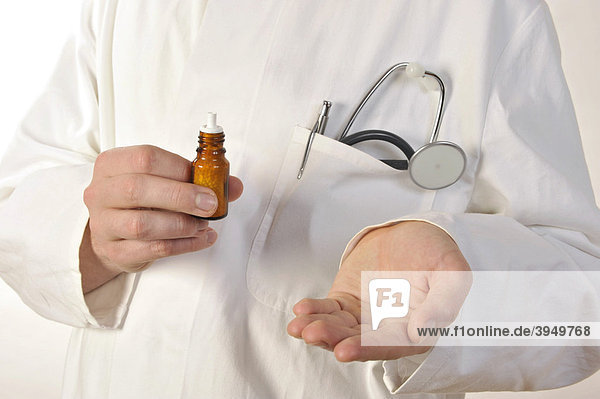 Arzt hält homöopathisches Medikament in der Hand