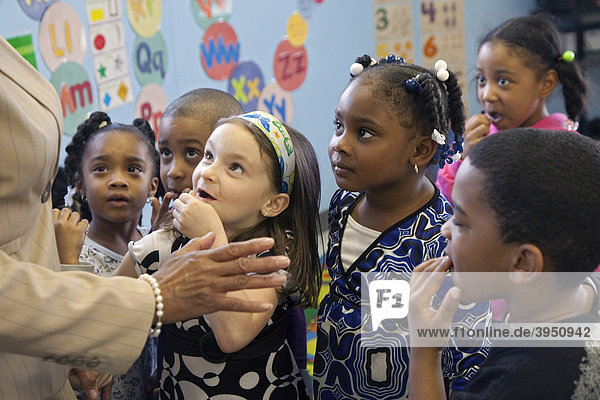 Children listen to a teacher at a child care center  Detroit  Michigan  USA