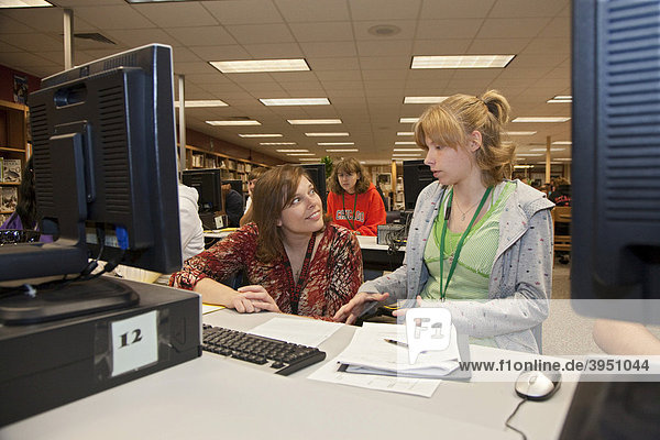 Medien-Spezialist Jodie Kleymeer hilft einer Schülerin bei der Arbeit am Computer im Medienzentrum  Bibliothek  an der Lake Shore High School  St. Clair Shores  Michigan  USA