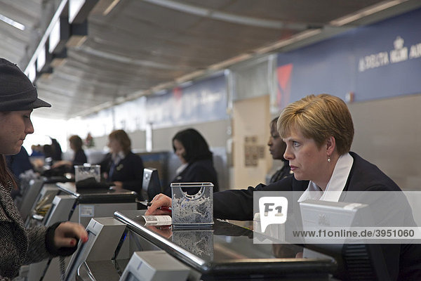 Angestellte checkt eine Reisende ein am Abfertigungsschalter der Delta  Northwest Airlines  Detroit Metropolitan Airport Flughafen  Romulus  Michigan  USA