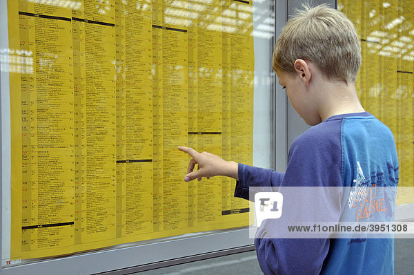 Ein neunjähriger Junge studiert den Fahrplan  Hauptbahnhof in Köln  Nordrhein-Westfalen  Deutschland  Europa