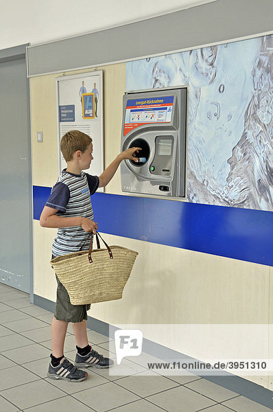 Neunjähriger Junge mit Pfandflaschen am Rückgabeautomat des Lebensmitteldiscounters ALDI  Köln  Nordrhein-Westfalen  Deutschland  Europa