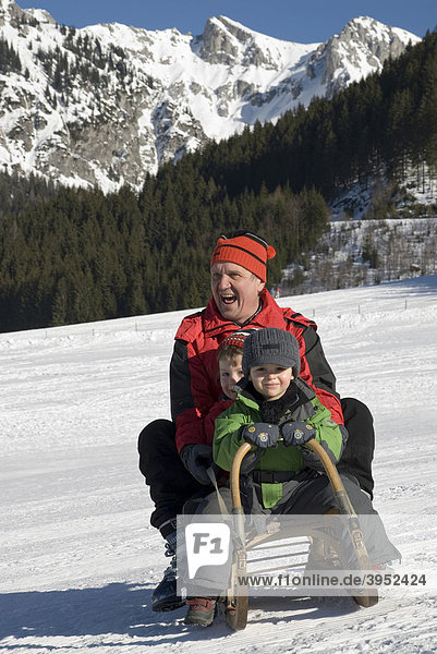 Man and children on a sledge