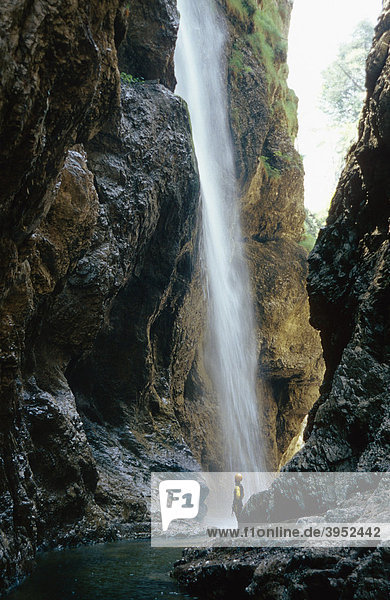 Eine Frau unter einem Wasserfall in einem Canyon  Talgau  Salzburg  Österreich