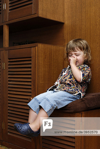 Ein zweijähriges Mädchen sitzt nach einem Wutausbruch auf dem Wut-Stuhl