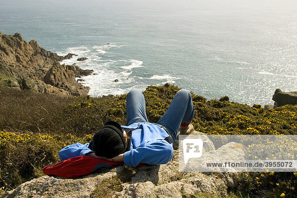 Frau liegt auf Stein  Rast  Pause  Wandern  Küste  Meer  Cornwall  Südküste  Südengland  England  Großbritannien  Europa