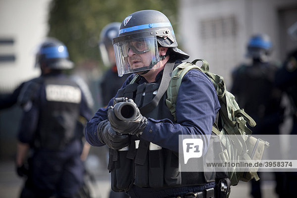 Polizist zielt bei Protesten gegen den NATO-Gipfel mit einem Abschussgerät für Tränengasgranaten  Straßburg  Frankreich