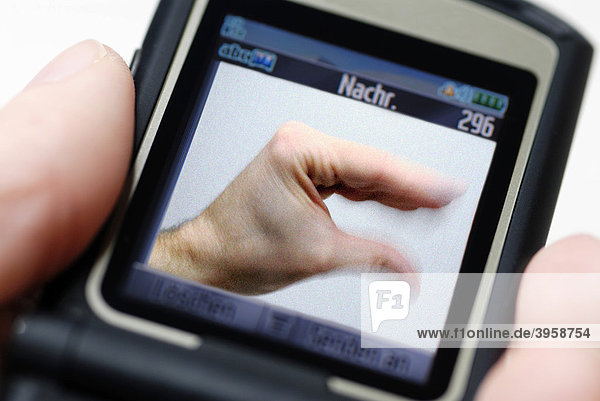 Mobile phone with a photo of a hand performing a blah-blah gesture  symbolic photo for mobile phone use and SMS
