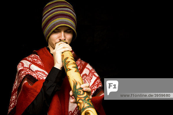 Junger Musiker in Tracht spielt Didgeridoo