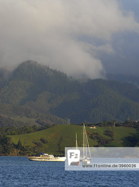 Küstenlandschaft mit Booten und Wolken im Abendlicht bei Coromandel Town  Coromandel Halbinsel  Neuseeland