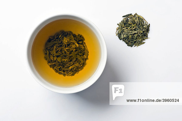 Green tea in tea bowl with dry Longjing tea  Chinese Dragonwell tea