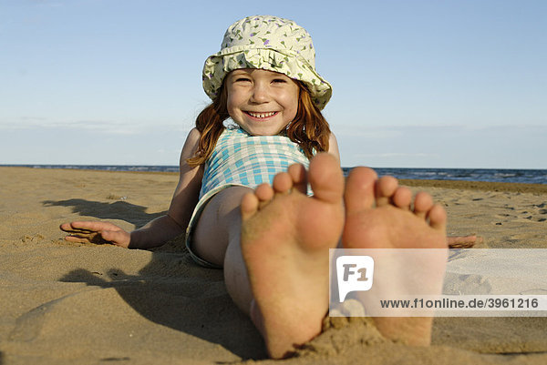 Mädchen liegt im Sand am Strand am Meer  Bibione  Adria  Venetien  Veneto  Italien  Europa