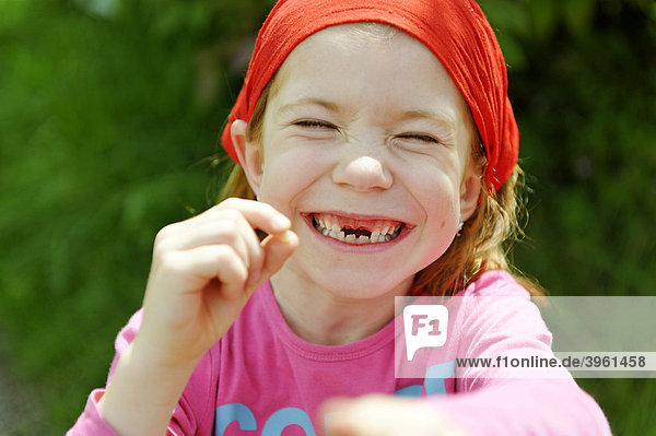 Kleines Mädchen mit Zahnlücke  Schneidezähne fehlen  freut sich über verlorenen Zahn  Zahnfee
