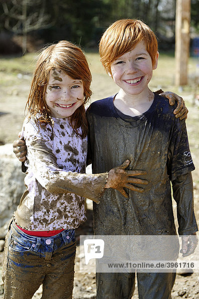 Children  totally covered in mud  dirty  wild  untypical girl