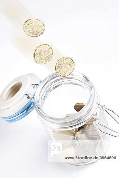 Münzen fallen in ein Einmachglas