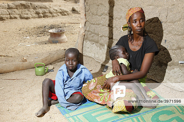 Frau  Mutter und zwei Kinder  vor dem Haus sitzend  Maroua  Kamerun  Afrika
