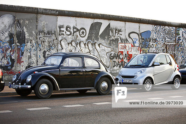 Generationen von Kleinwagen  VW Käfer und Smart ForTwo an der East Side Gallery in Berlin  Deutschland