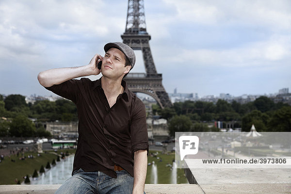 Junger Mann vor dem Eiffelturm  Paris  Frankreich  Europa
