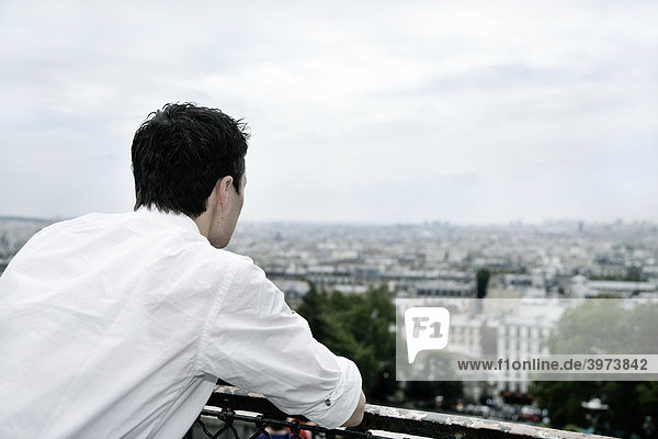 Junger Mann blickt auf Paris  Frankreich  Europa