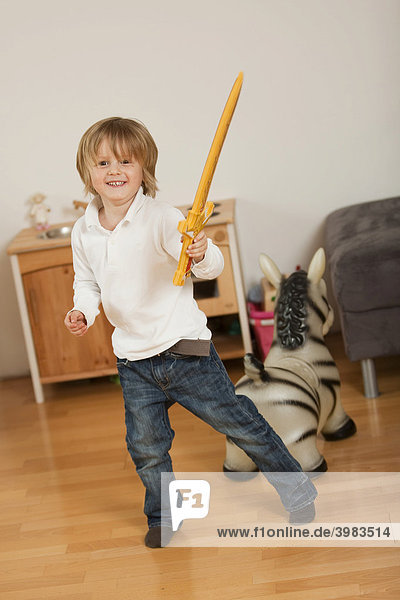 Kleiner Junge  3-jährig  posiert mit einem Schwert