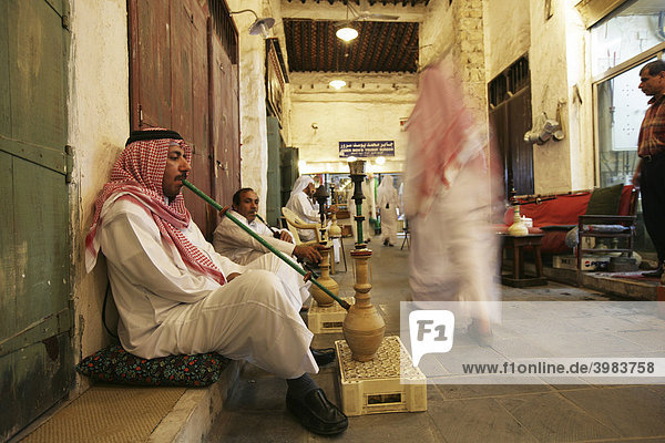 Men using a hookah or shisha in a cafe in Souq al Waqif market  the oldest Souq or bazaar in the country  Doha  Qatar