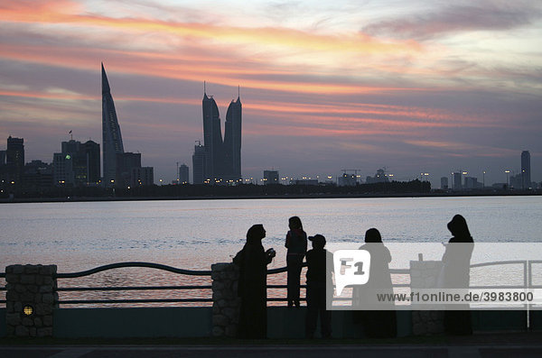 Skyline von der Corniche am King Faisal Highway gesehen  Muharraq Seite  World Trade Center Gebäude  links  daneben die Türme des Financial Harbour Komplex  abendliche Spaziergänger an der Corniche  Hauptstadt Manama  Königreich Bahrain  Persischer Golf