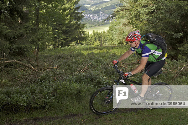 Mountain bike rider riding along a singletrail on Kahlen Poen mountain near Usseln  Hesse  Germany  Europe