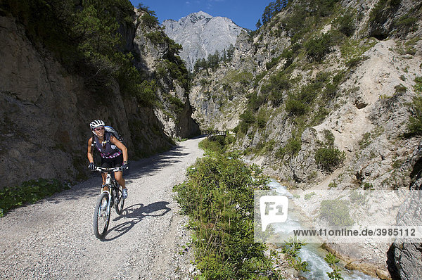 Female mountainbike rider riding through the Giessenbachklamm gorge  southeast of Scharnitz  Tyrol  Austria  Europe