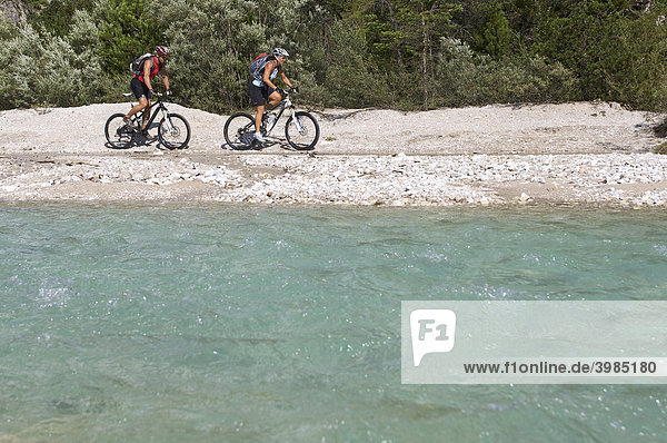 Montainbike riders  female and male  beside the Isar River near the Wiesenhof Hotel near Scharnitz  Tyrol  Austria  Europe