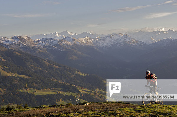 Mountainbiker at Hohe Salve mountain  the Grossvenediger mountain in the back  Tyrol  Austria  Europe